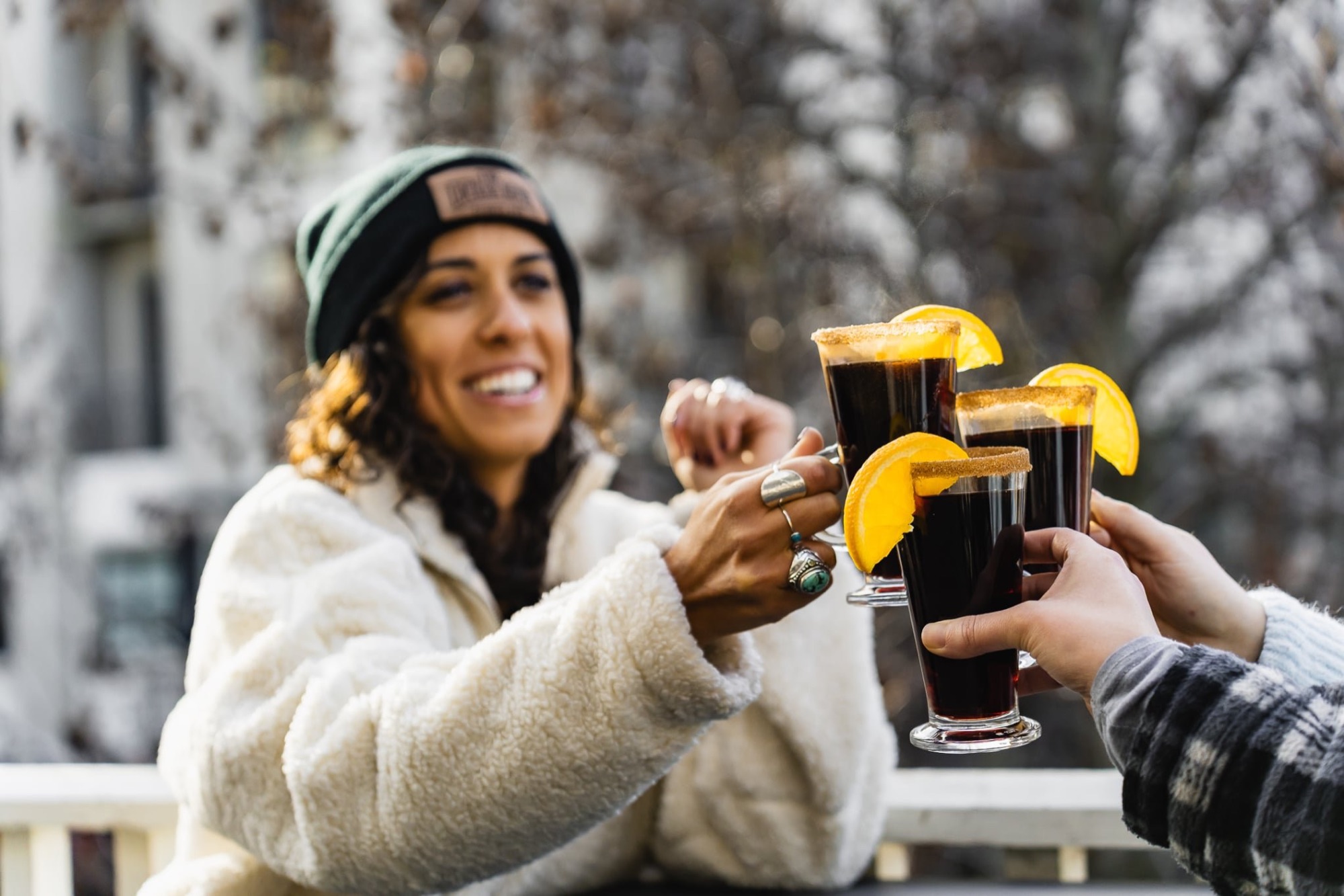 Friends cheersing mulled wine cocktails outside The Locker Room