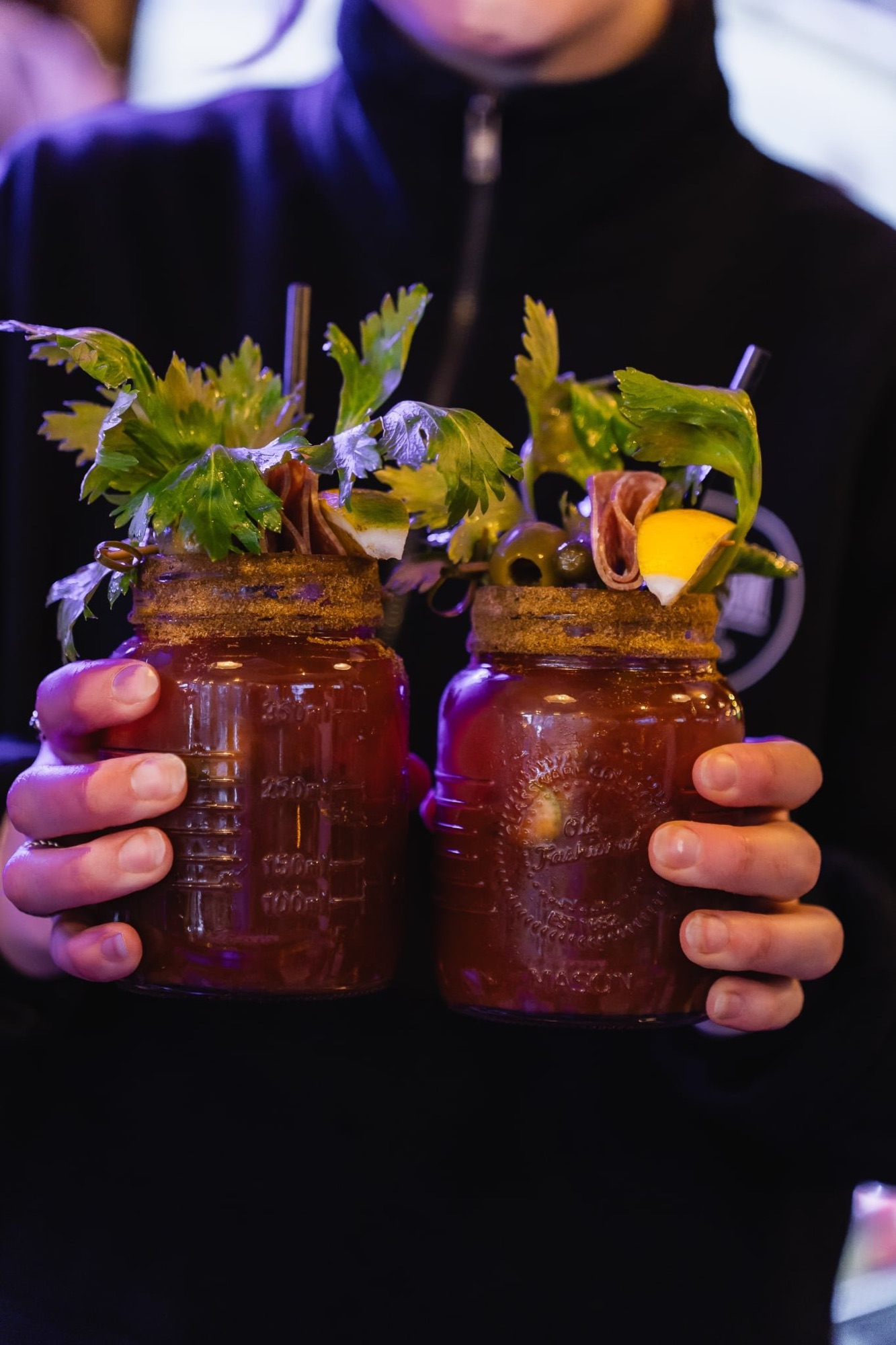 Two garnished Bloody Mary cocktails in mason jars at The Locker Room