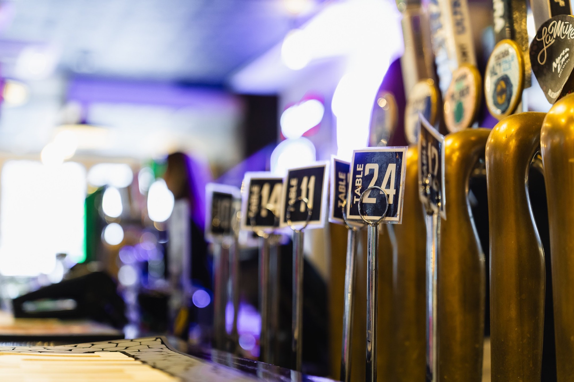 Row of beer taps with reserved table number cards at The Locker Room