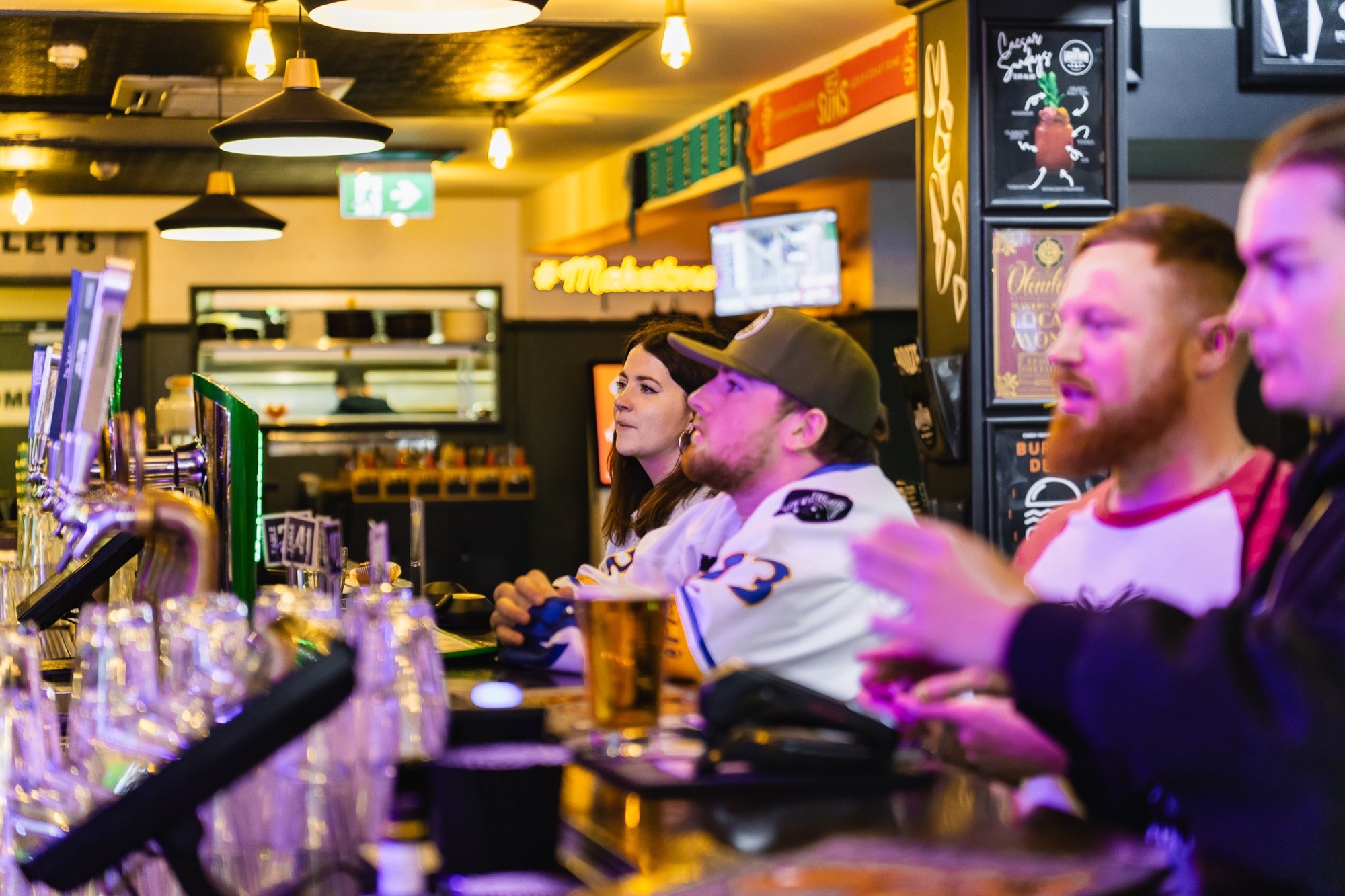 Patrons at the bar watching live sport on the screens at The Locker Room