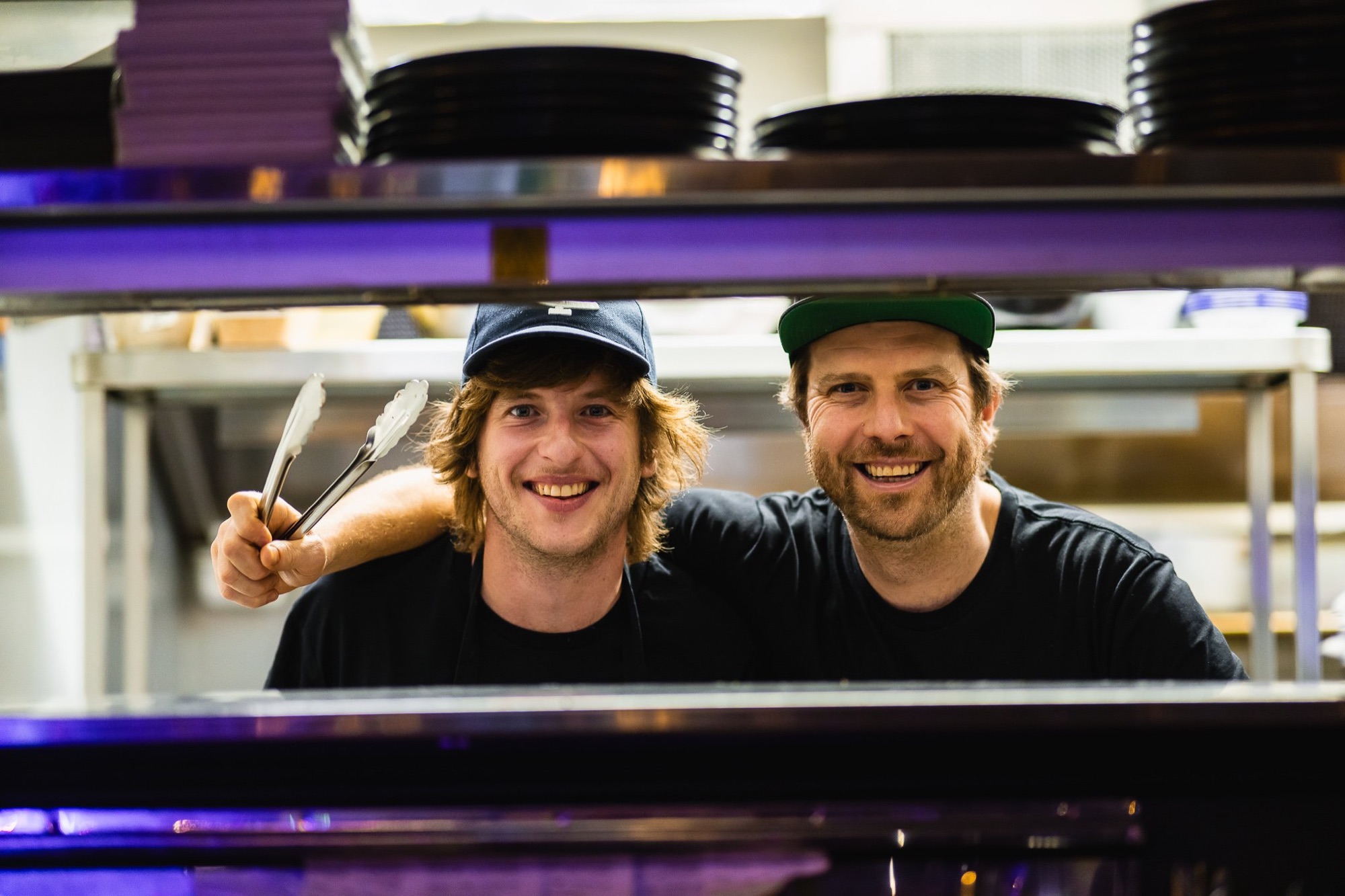 Kitchen staff smiling behind the pass at The Locker Room