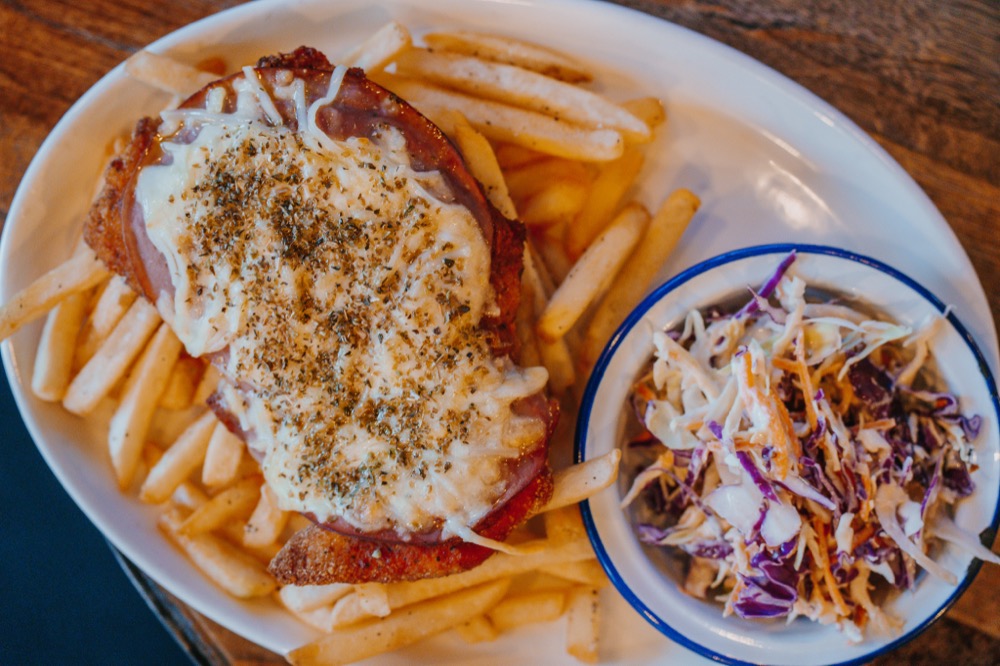 Chicken parmi topped with ham, cheese and herbs at The Locker Room