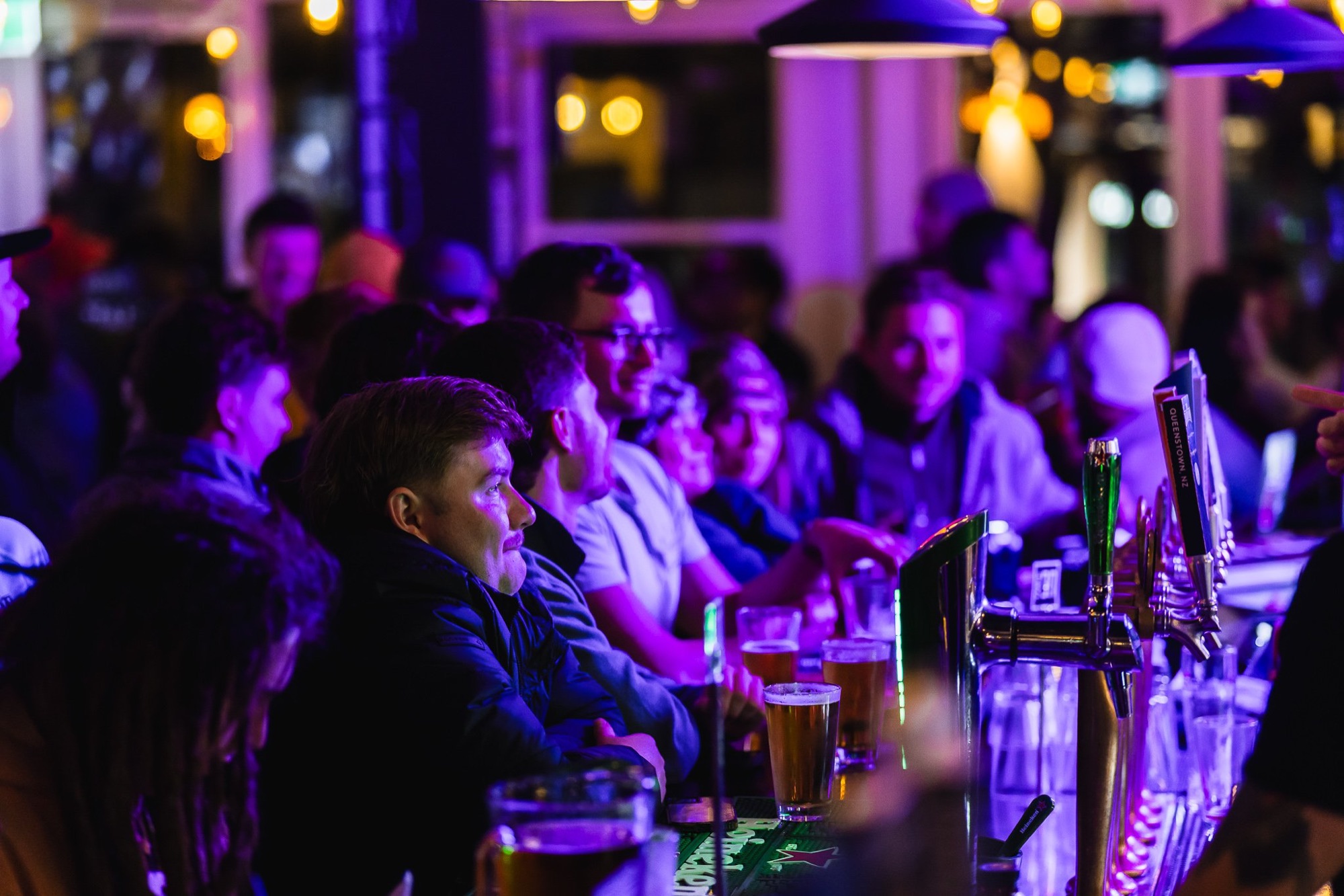 Crowd gathered around the bar taps on a busy night at The Locker Room