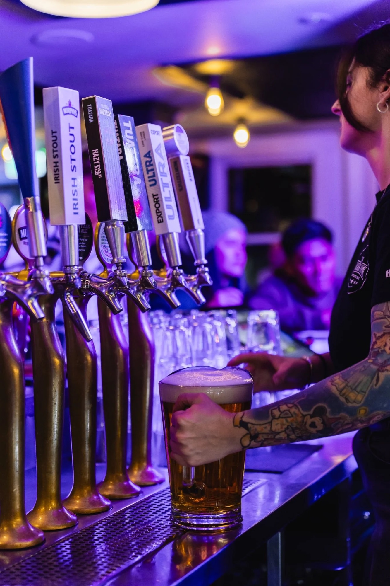 Bartender pouring a beer from the tap lineup at The Locker Room