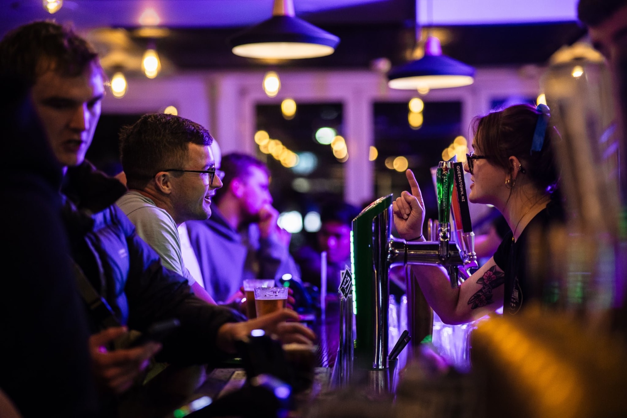 Two friends toasting drinks at the bar at The Locker Room