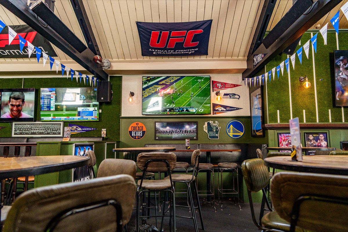 Games area with screens and sports flags at The Locker Room