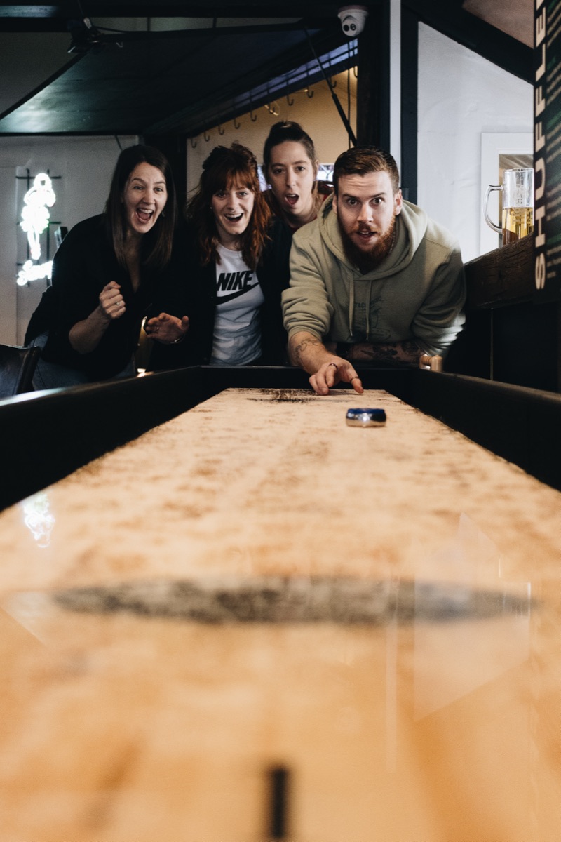 Group playing shuffleboard during a staff party at The Locker Room